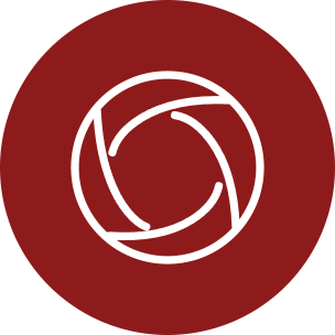 A circular red icon with a white aperture-style lens symbol in the center, shown on a plain white background.