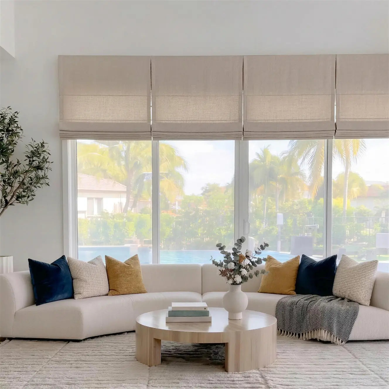 Modern living room with a sectional sofa, coffee table, and large windows.