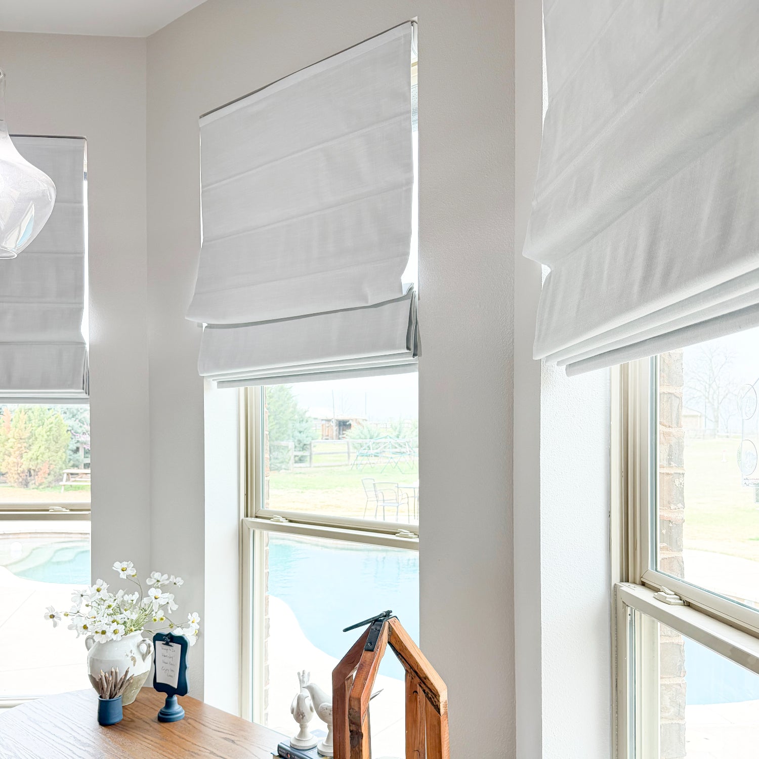 Smart window blinds in a modern living room with a view of a garden.
