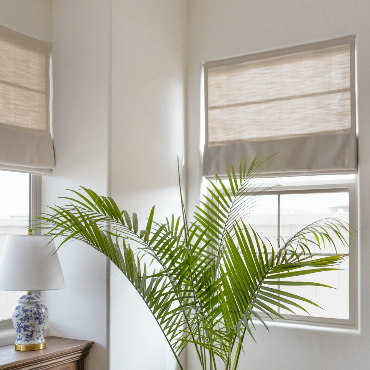 Ilythra cotton linen roman shades in a living room corner view 1