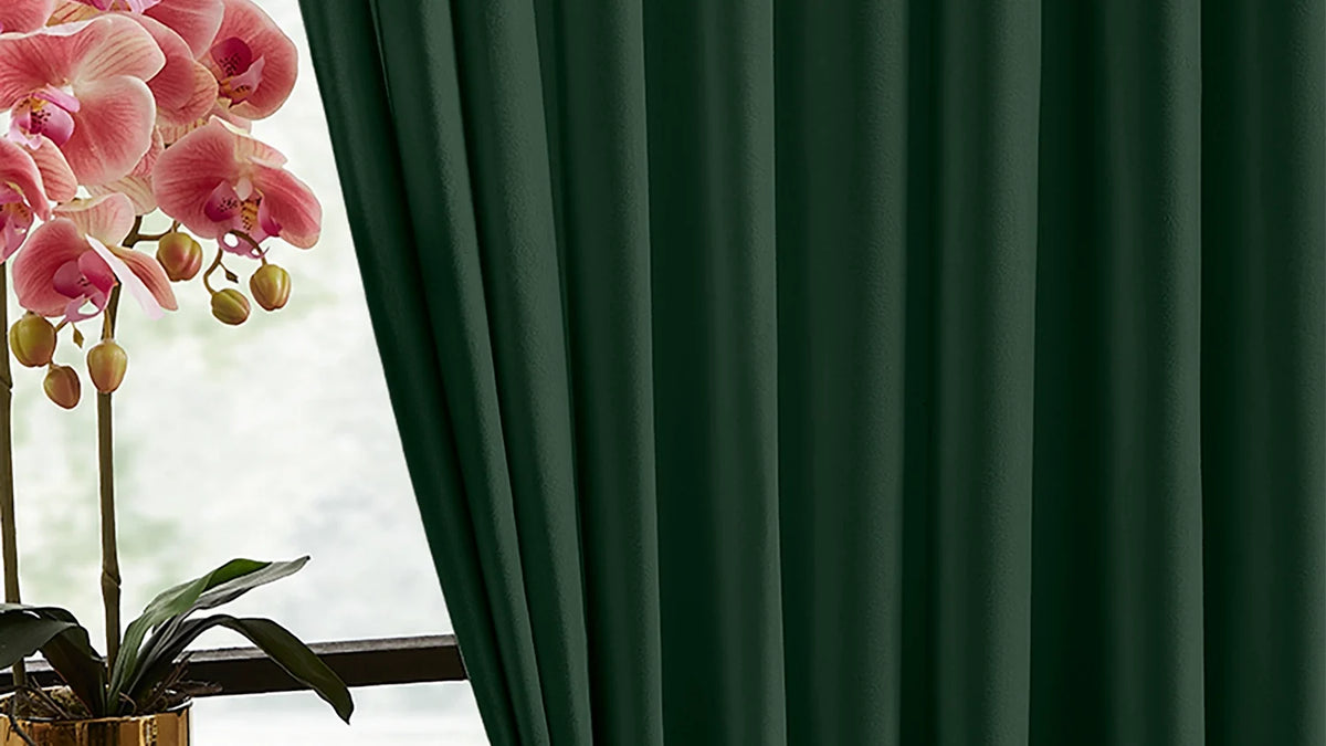Deep green velvet drapes drawn across a window