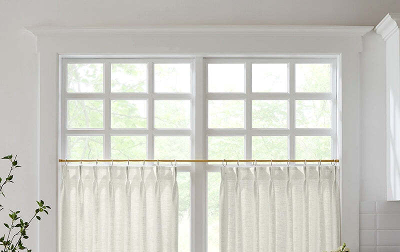 Off-white linen café curtains on a bright bathroom window, giving privacy on the lower half with daylight above
