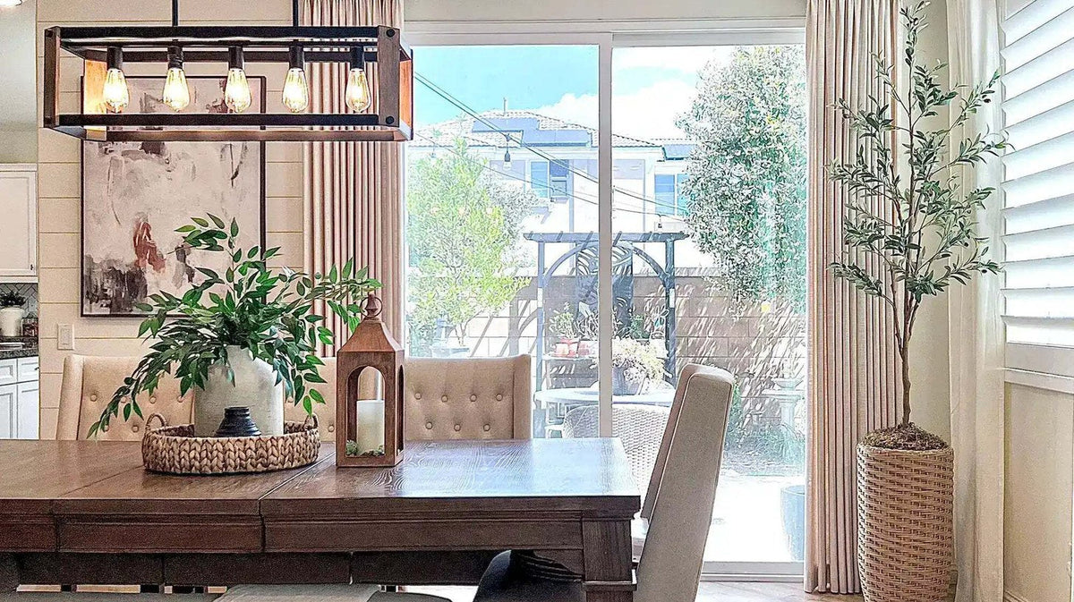Dining room with layered curtains framing a sliding glass door