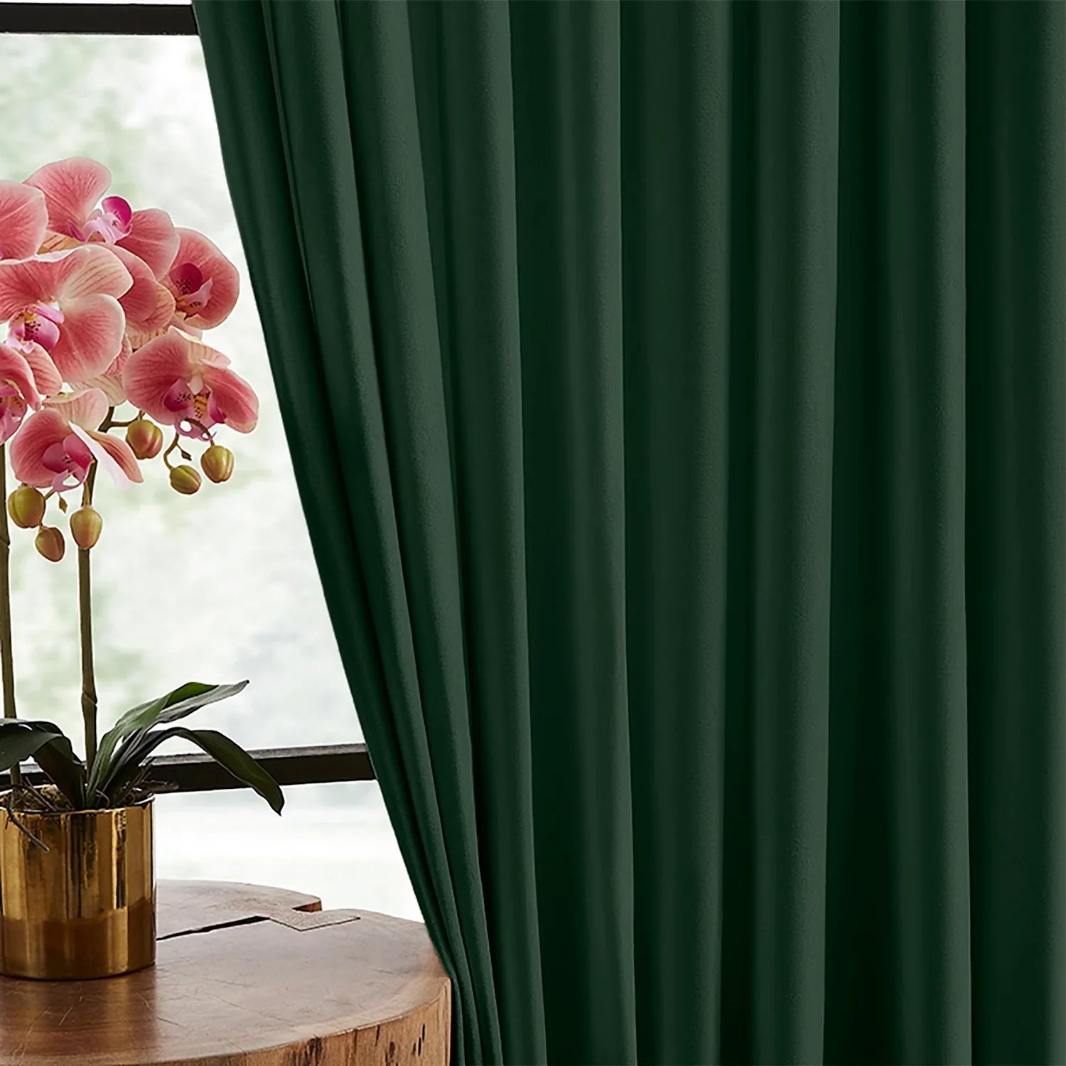 Deep green velvet drapery falling in soft, continuous rounded folds beside a bright window