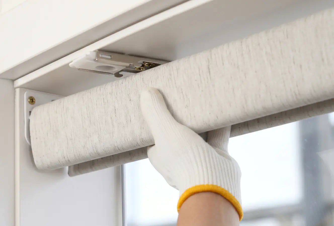 Person using a tool to install or adjust a light fixture on a ceiling.
