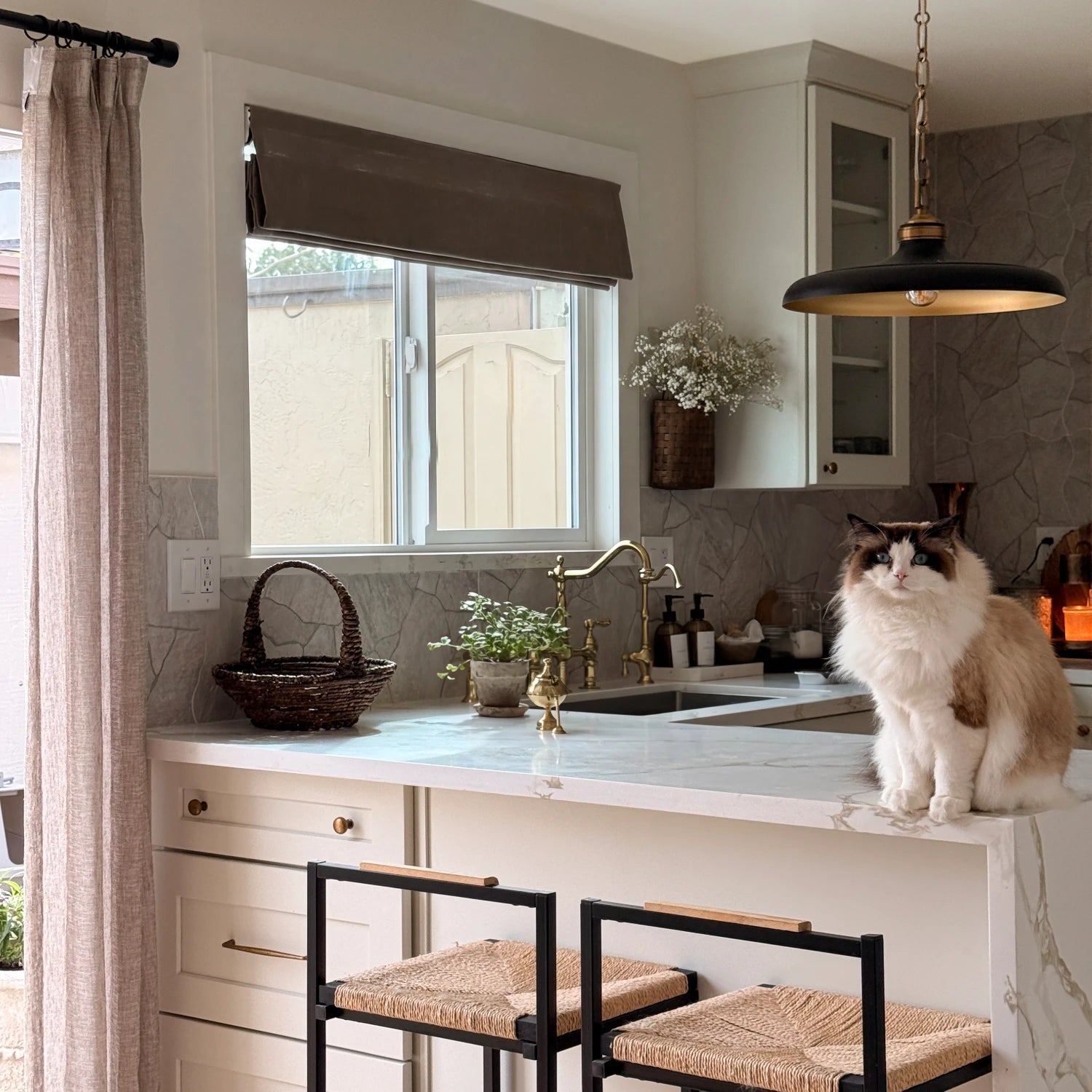 Elara 89850-10 elegant linen Roman shades open in a kitchen with a cat on the counter view 5